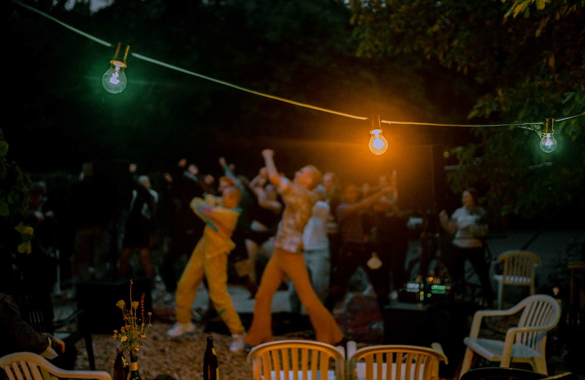 Lichterkette im Vordergrund und Menschen tanzen